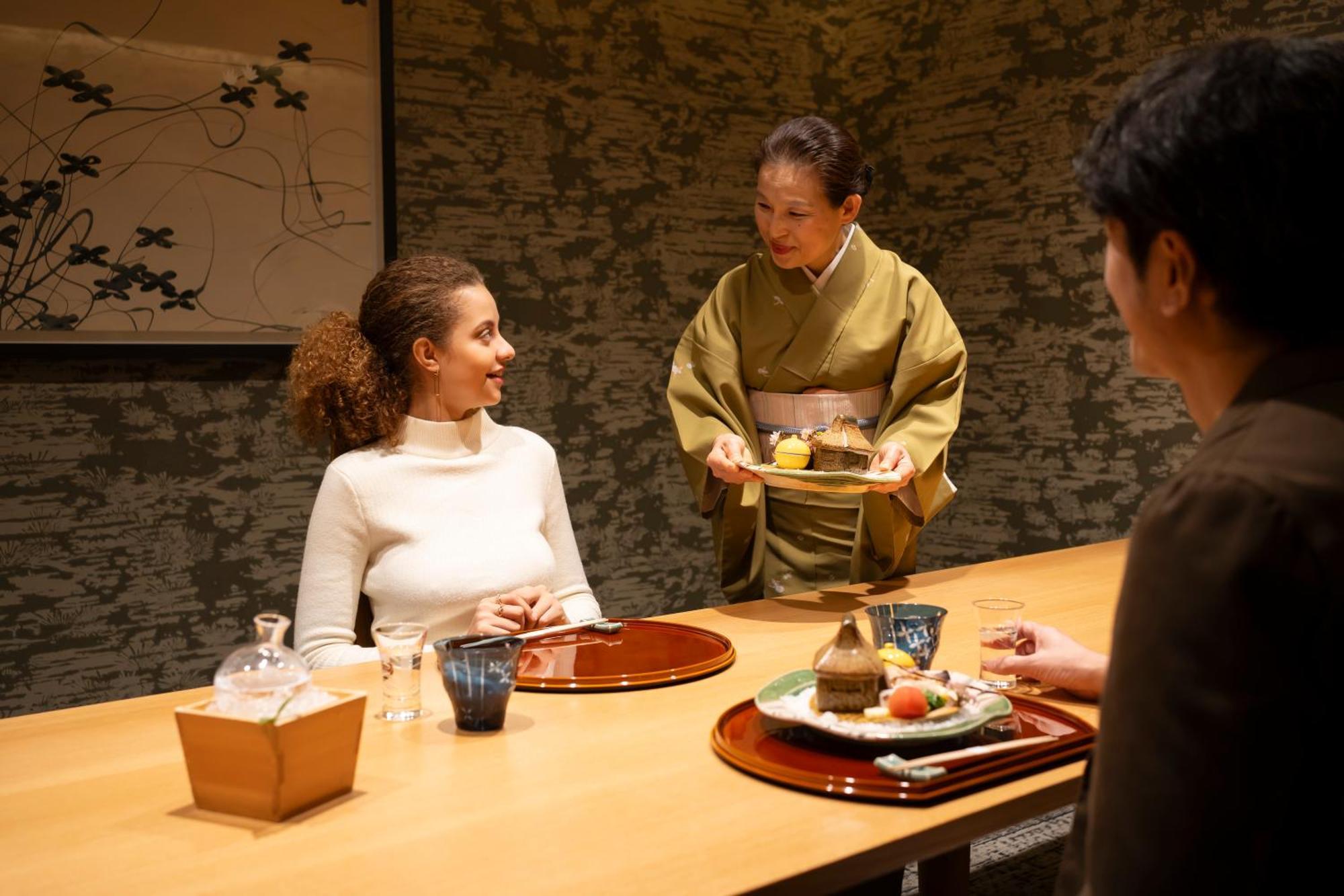 호텔 아소시아 시즈오카 외부 사진 A woman serving tea at a Japanese restaurant